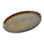 A oval wooden tray with brass handles Please Note - we do not make reference to the condition of