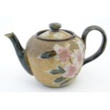 A Royal Doulton stoneware teapot decorated with flowers and foliage. Marked under Doulton Slaters