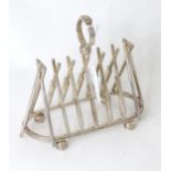 A silver plate novelty toast rack, the bars formed as crossed cricket bats 7 1/4" long Please Note -