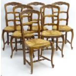 A set of early / mid 20thC oak dining chairs with shaped carved frames and having envelope rush