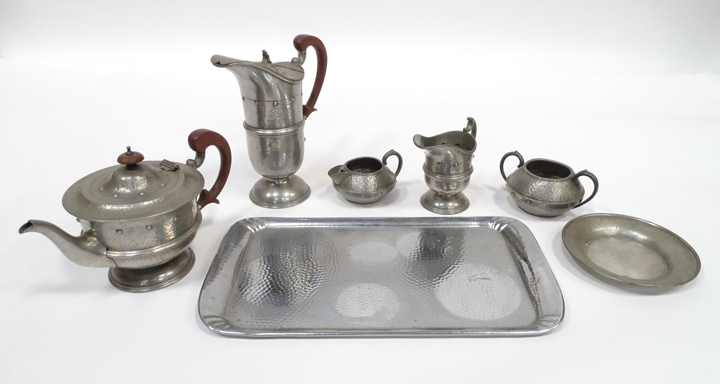 A quantity of Arts & Crafts style pewter tea wares with hammered decoration comprising teapot,