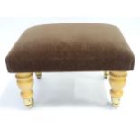A foot stool with turned wooden legs and brass castors. Approx. 18" wide x 12" high Please Note - we