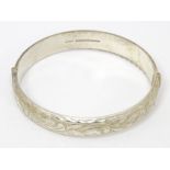 A silver bracelet of bangle form with engraved decoration Pat No. 2004732. Please Note - we do not