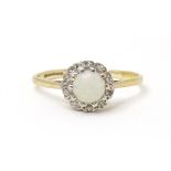 A 9ct gold ring set with central opal cabochon bordered by diamonds. Ring size approx. M Please Note