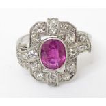 A platinum pink sapphire and diamond ring the central pink sapphire bordered by diamonds in an Art