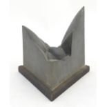 A 20thC cast aluminium modernist abstract sculpture of triangular form, mounted on a wooden base.