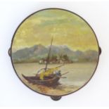 A 20thC tambourine, the drum painted in oils depicting a Continental lake scene with fisherman, boat