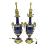 A pair of Continental ceramic and gilt metal table lights, the blue glazed body of vase form with