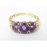 A 9ct gold ring set with 3 amethysts flanked by diamonds. Ring size approx. L 1/2 Please Note - we