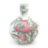 A Chinese famille rose bottle vase decorated in the nine peaches pattern with a fruiting tree with