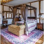 A 20thC oak four poster bed with a carved frame and a nulled frieze, having cup and cover supports