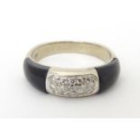 A white gold ring with diamonds and black enamel detail. Ring size approx. M Please Note - we do not