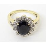 A 9ct gold ring set with central black stone bordered by diamonds. Ring size approx Q Please