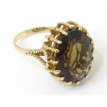 A 9ct gold ring with basket set smoky quartz stone. Ring size approx. L. Please Note - we do not