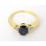 An 18ct gold ring set with central sapphire flanked by two diamonds. Ring size approx P 1/2 Please
