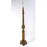 An early 20thC oak standard lamp, adorned with carved fruit, flowers and leaves. Having a