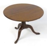 A late 18thC mahogany tripod tilt top table with a circular top above a turned stem and three