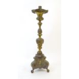 A late 19thC floor standing cast ecclesiastical candlestick with relief swag, foliate and fruit