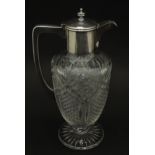 A cut glass claret jug with silver plate mounts and handle. Approx 11 1/2" high Please Note - we
