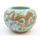 A Chinese vase / pot decorated in relief with dragons, flaming pearl, stylised clouds and waves.