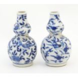 A pair of small Chinese blue and white double gourd vases decorated with birds, flowers and foliage.