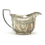 A silver cream jug with embossed acanthus and C scroll decoration, hallmarked Chester 1903, maker