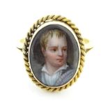 A yellow metal ring set with hand painted cabochon to centre depicting miniature portrait of a young