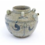 An Oriental stoneware water pot / jar with four loop handles, a spout and crackle glaze with blue