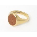 A 9ct gold signet ring set with goldstone. Ring size approx T 1/2 Please Note - we do not make