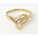 A gold ring of snake form set with central diamond. The diamond approx. 0.25ct ring size approx. N