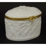A Limoges parian ware oval box with a hinged lid, decorated in relief with dancing putti /