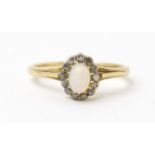 A gold ring set with central opal boarded by diamonds. Ring size approx. R Please Note - we do not