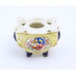 A Continental porcelain inkwell of shaped form with floral and foliate detail and gilt highlights.