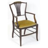 An Edwardian open armchair / elbow chair, having a shaped top rail with inlaid decoration and a