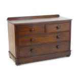 A late 19thC mahogany chest of drawers with a shaped upstand above two short over three long drawers