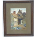 An early 20thC watercolour depicting a timber framed house with stable arch. Signed G M Kemp and