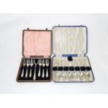 A cased set of silver plate cake forks and served together with a cased set of six silver plated