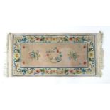 Carpet / Rug : A pink ground rug with flora motifs within a cream border with further floral and
