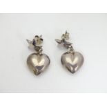 A pair of silver and white metal earrings with heart shaped drops below a star. Stamped 925. Approx.