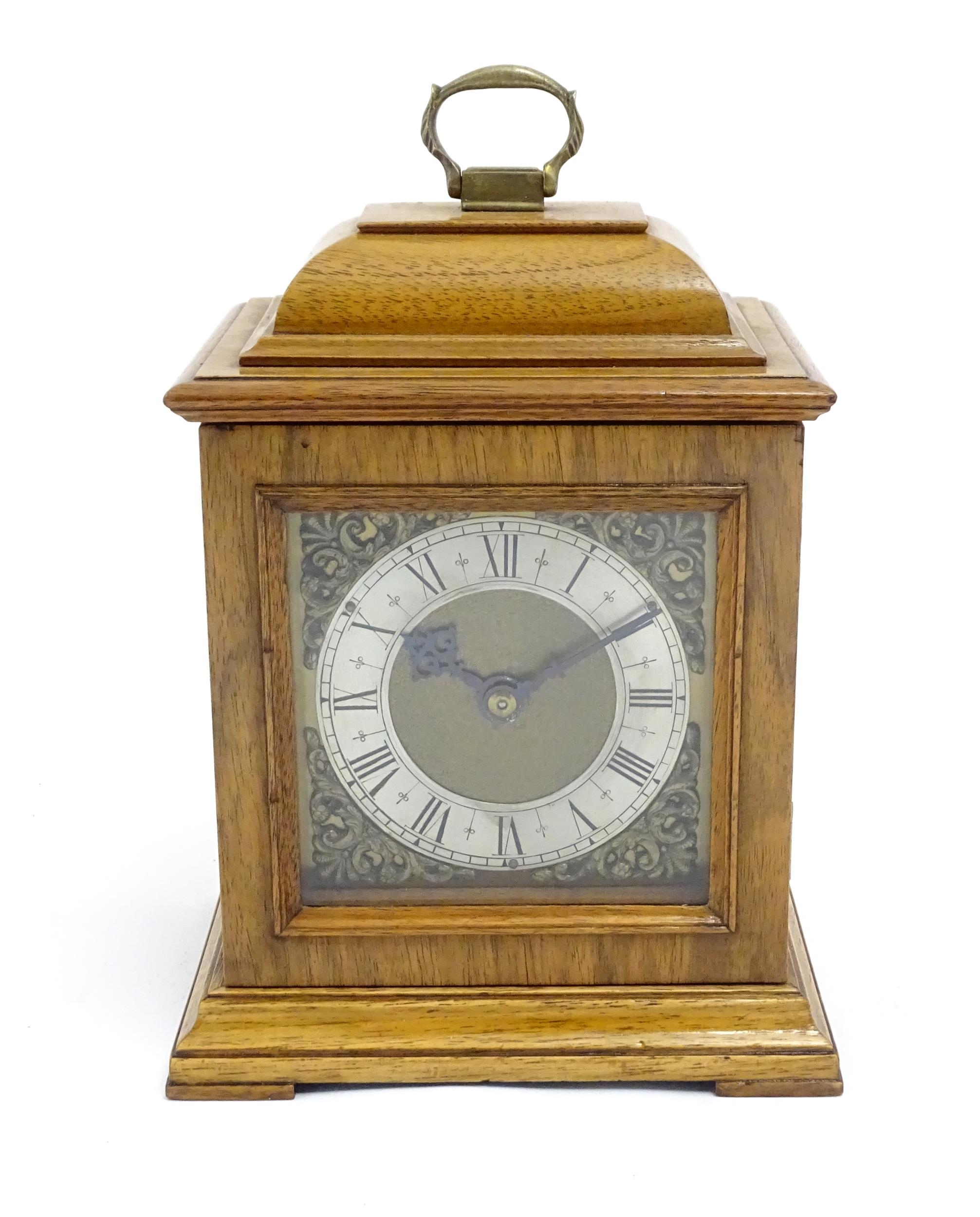 A 20thC walnut cased mantle clock with brass dial and silvered chapter ring with Roman numerals.