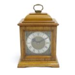 A 20thC walnut cased mantle clock with brass dial and silvered chapter ring with Roman numerals.