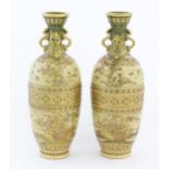 A pair of Japanese satsuma vases with twin handles decorated with flowers, foliage, birds, etc. with