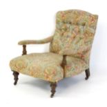 A late 19thC / early 20thC Howard style armchair with a button back and deep seat, the arms raised