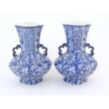 A pair of Continental blue and white twin handled vases with floral / blossom decoration, the neck