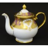 A De Lamerie Fine Bone China teapot in the pattern Royal Bow with gilt highlights. Marked under.