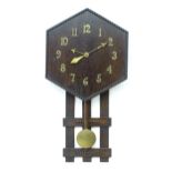 An Arts and Crafts style oak wall clock, the hexagonal dial with Arabic brass numerals and