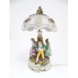 A Continental 20thC ceramic figural table lamp and shade with encrusted flowers and lithophane style