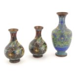Three Oriental cloisonne vases, one decorated with scrolling floral and foliate detail, and a pair