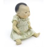 Toy: An Armand Marseille Oriental baby doll the bisque head with painted lips, composite body with