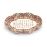 A Chinese dish of shaped form with a pink ground decorated with Character script bordered by